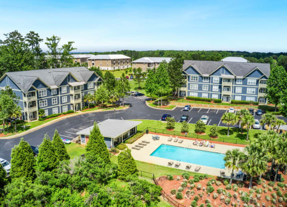 an aerial view of a resort style community with a swimming pool and parking lot