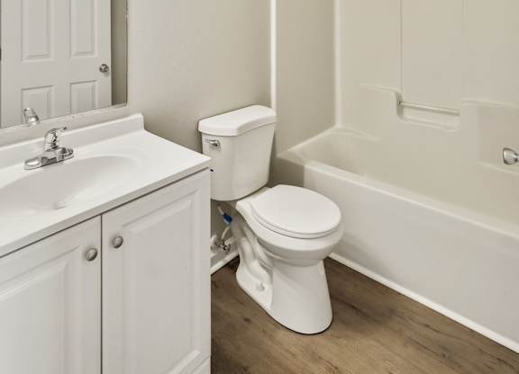A white bathroom with a toilet, sink, and bathtub.