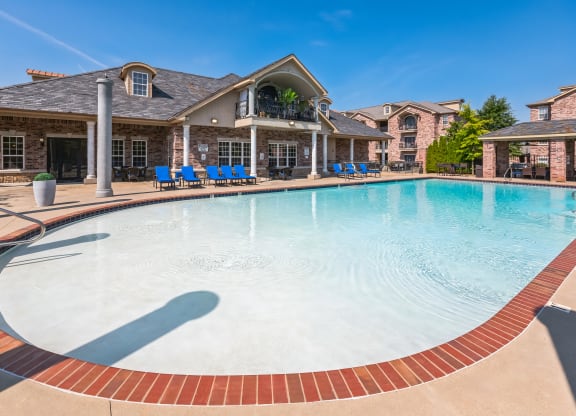 a large swimming pool with a house in the background