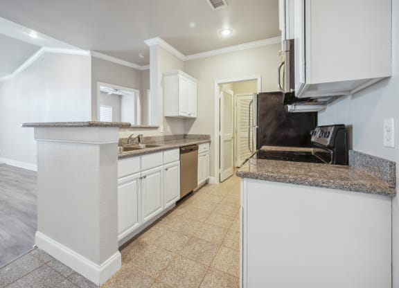 a kitchen with white cabinets and a counter top and a sink