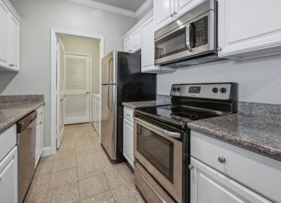 a kitchen with white cabinets and stainless steel appliances