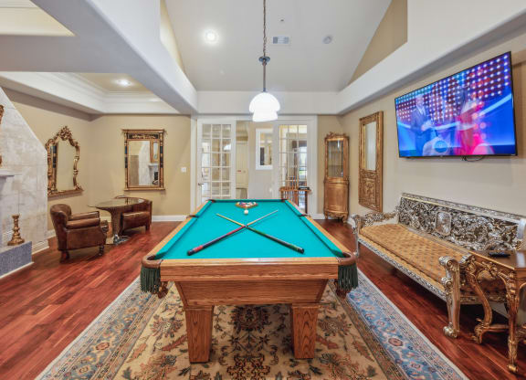 a game room with a pool table and a tv