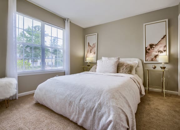 a bedroom with a bed and two windows