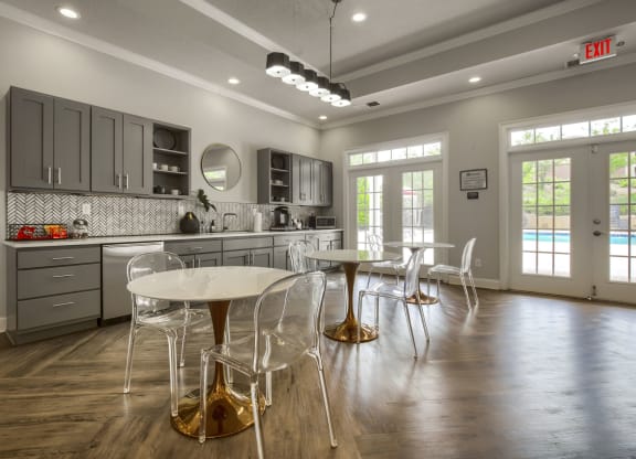 a kitchen with gray cabinets and a white table and chairs