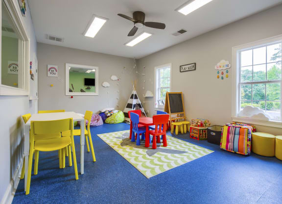 a childs play area with a table and chairs and a television