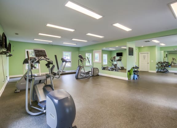 a large fitness room with treadmills and other exercise equipment