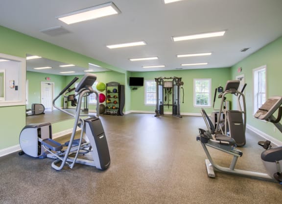 an exercise room with treadmills and other fitness equipment