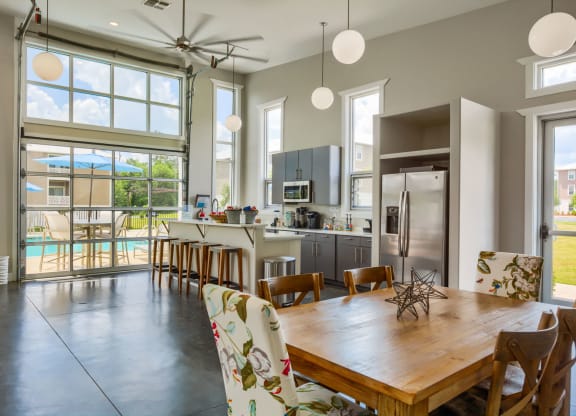 a kitchen with a large window and a wooden table with chairs