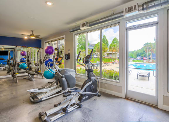 a home gym with a view of the pool