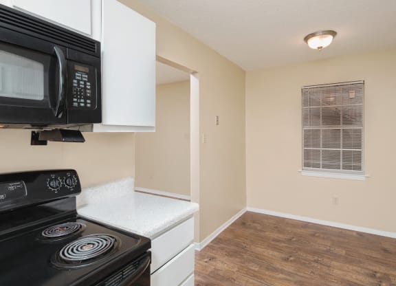 an empty kitchen with a stove and a microwave