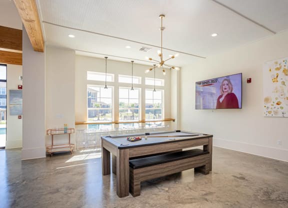 a game room with a pool table and a tv