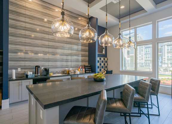 a kitchen with a large counter top and chairs