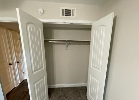 a bedroom with a closet and a closet door open