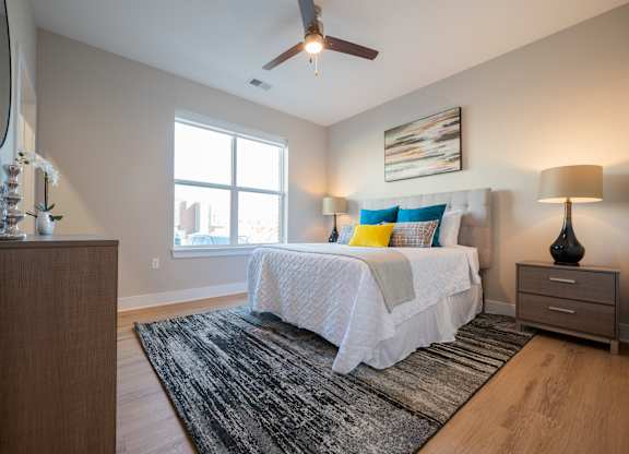 A bedroom with a bed, nightstands, and a rug.
