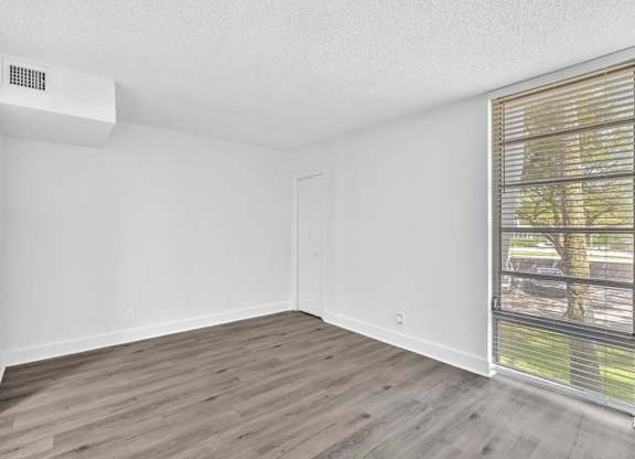 A room with a window and a wall-mounted air conditioner unit.