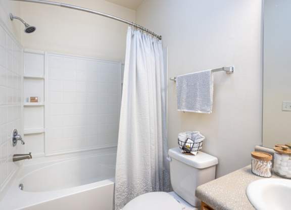A white bathroom with a toilet, sink, and bathtub.