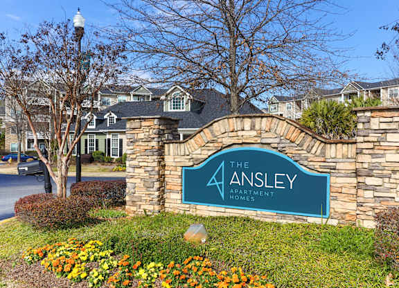 the apartments sign in front of a stone wall