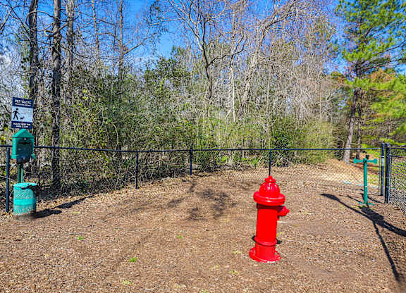 a red fire hydrant in front of a fence