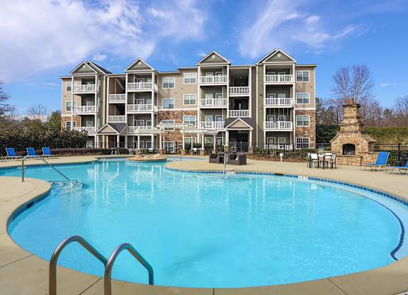 a large swimming pool with an apartment building in the background
