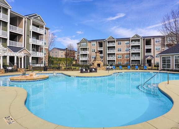 a large swimming pool with an apartment building in the background