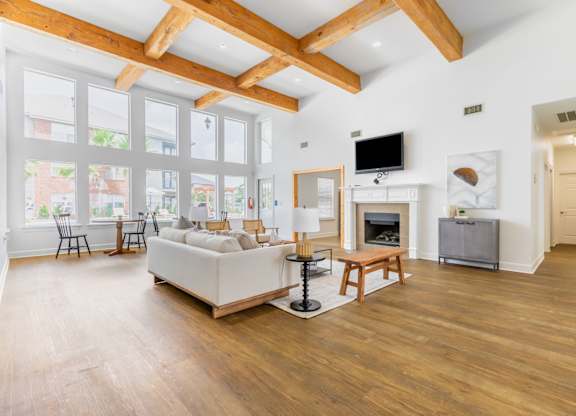 A spacious living room with wooden floors and a high ceiling.