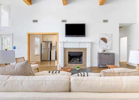 A living room with a fireplace and a television on the wall.
