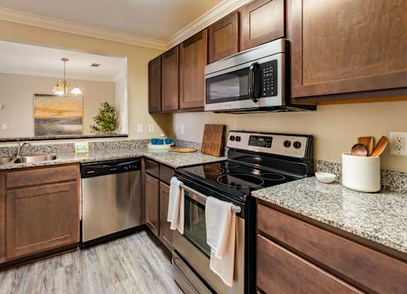 A kitchen with a black stove top oven and a black microwave above it.