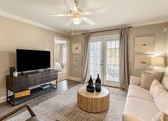 A living room with a flat screen TV and a white sofa.