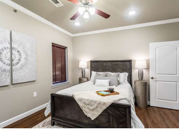 A bedroom with a large bed and a ceiling fan.