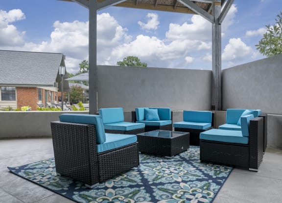 an outdoor patio with blue chairs and a coffee table
