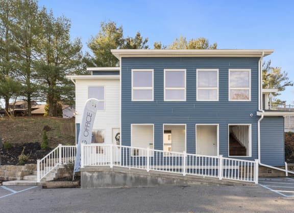 a blue house with a white fence in front of it