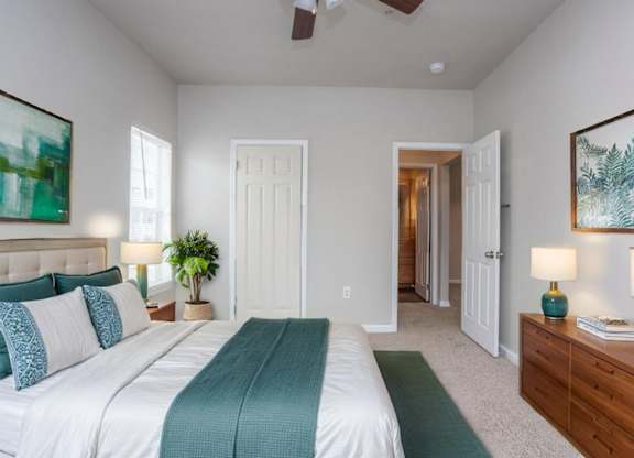 A bedroom with a large bed and a painting on the wall.