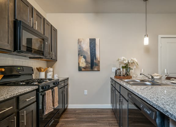 private kitchen with granite countertops and stainless steel appliances and a sink