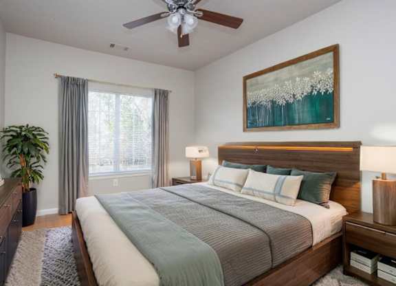 A bedroom with a large bed and a painting on the wall.