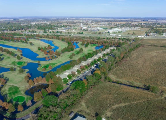an aerial view of a golf course with a river in the background