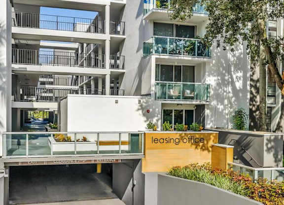 A modern building with a leasing office in front.