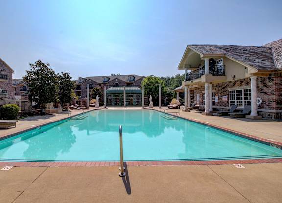 A large swimming pool in front of a resort.