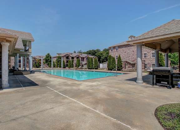 A swimming pool surrounded by houses and trees.