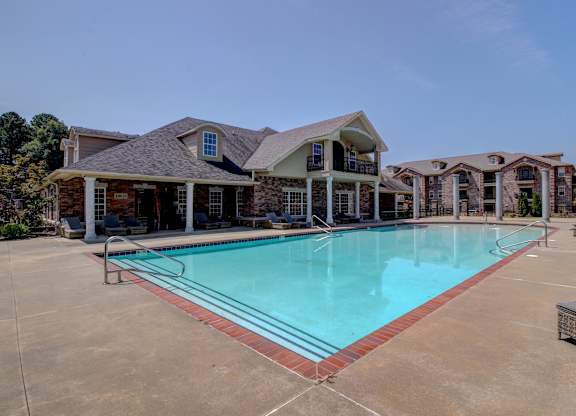 A large swimming pool in front of a house.