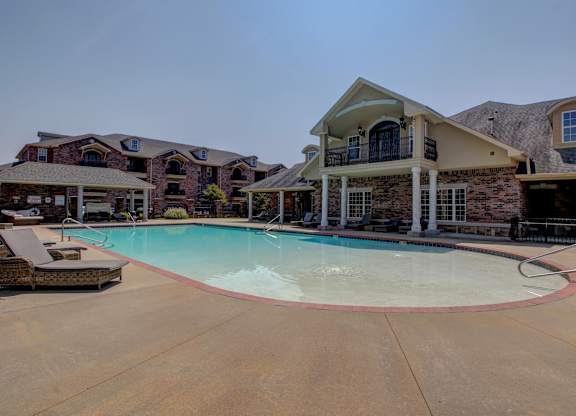 A large house with a pool in front.