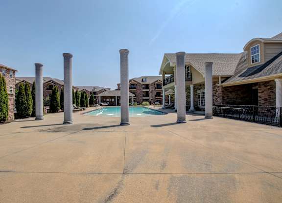 A large open courtyard with a pool and pillars.