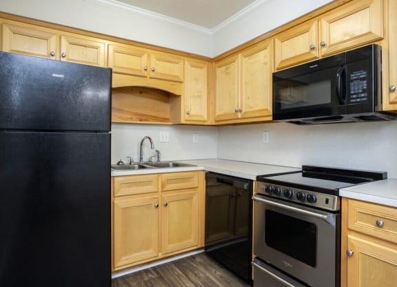 a kitchen with black appliances and wooden cabinets
