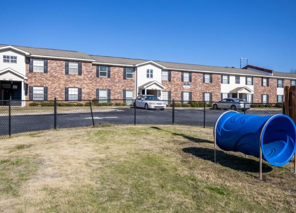 a blue barrel in front of a brick building