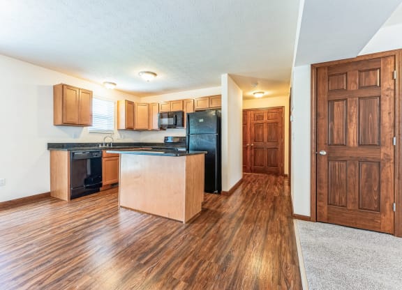 a kitchen with an island and a black refrigerator