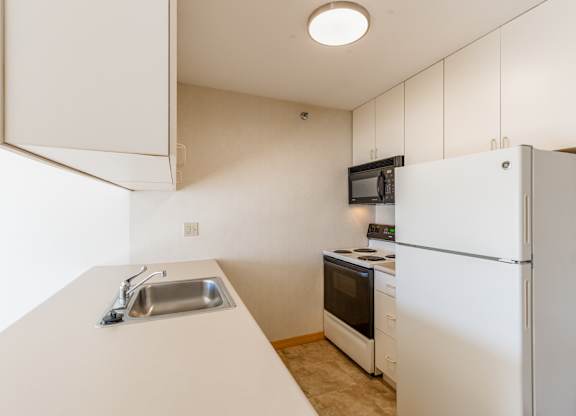A kitchen with white appliances and a white counter.