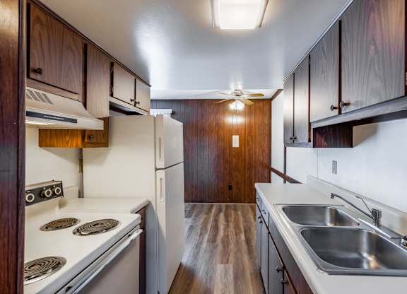 A kitchen with a stove top oven and a refrigerator.