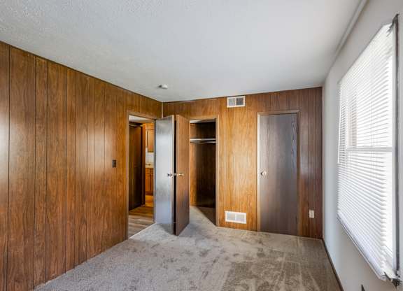 A hallway with wooden walls and a carpeted floor.