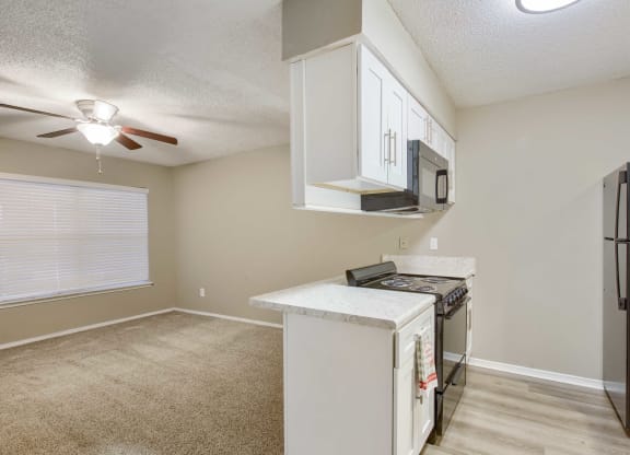 a kitchen and living room with a ceiling fan