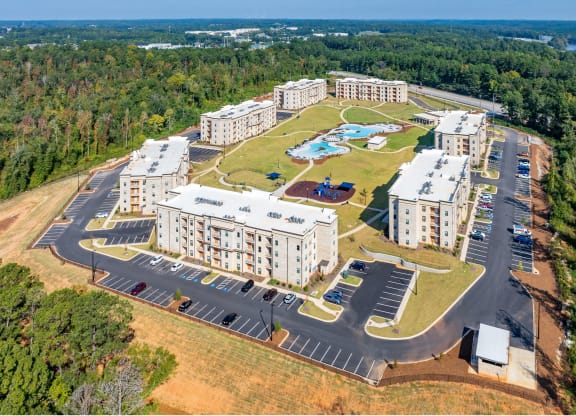 an aerial view of an apartment complex with buildings and a parking lot