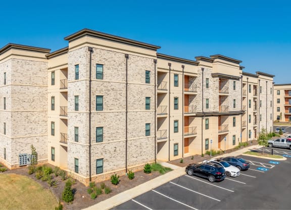 a large apartment building with cars parked in a parking lot